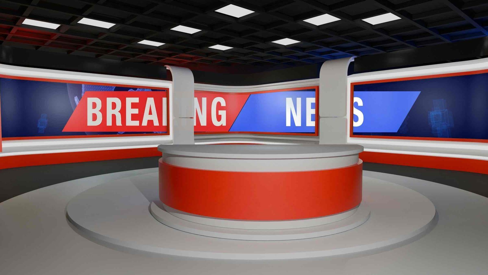 An empty television news studio with a circular desk under a breaking-news screen.