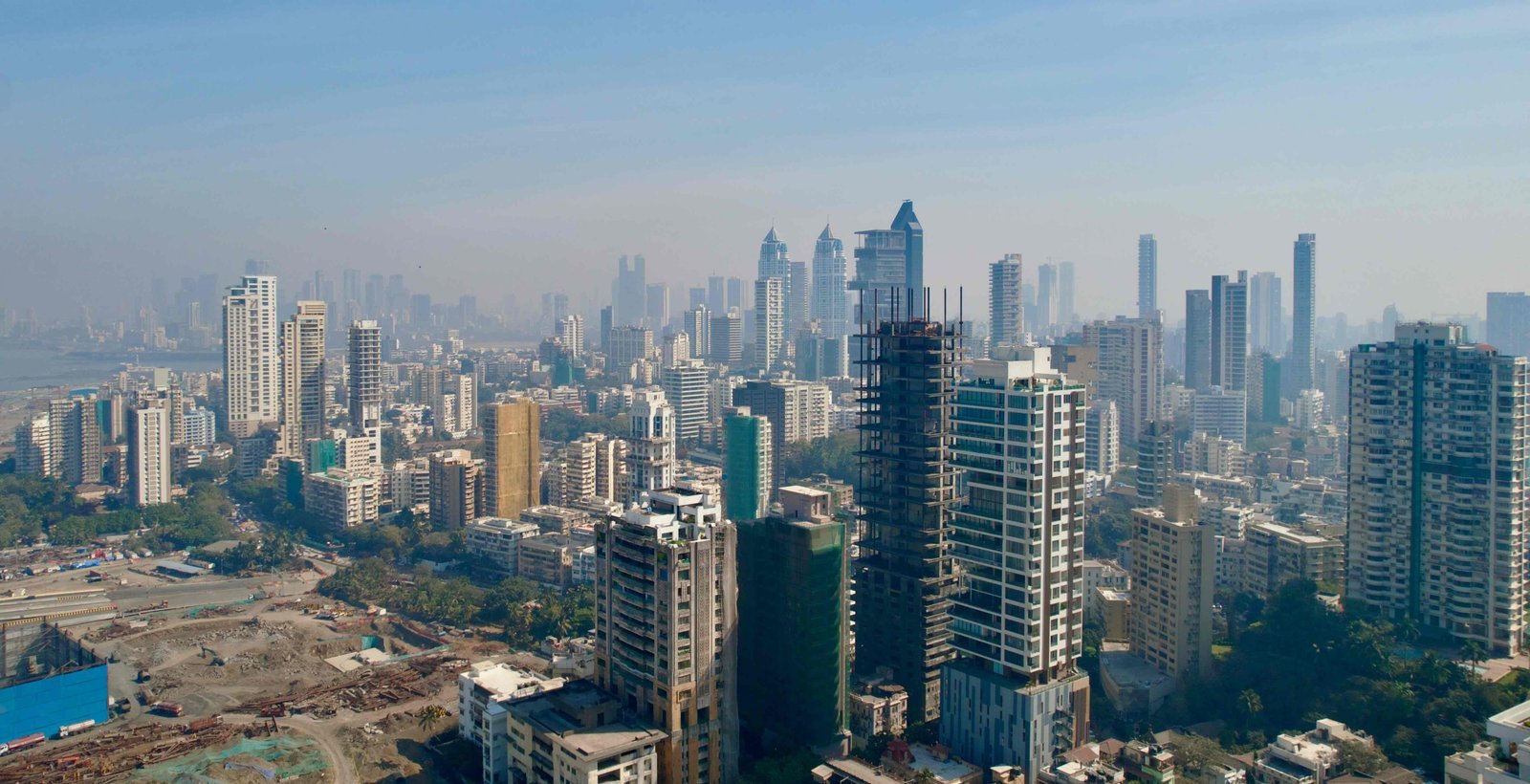 Aerial view of a dense city skyline of residential towers in haze.